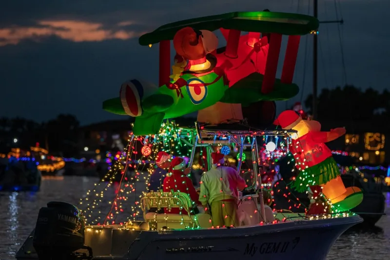 Boat decorated with holiday lights and inflatables in the Cape Coral Holiday Boat-a-Long at dusk