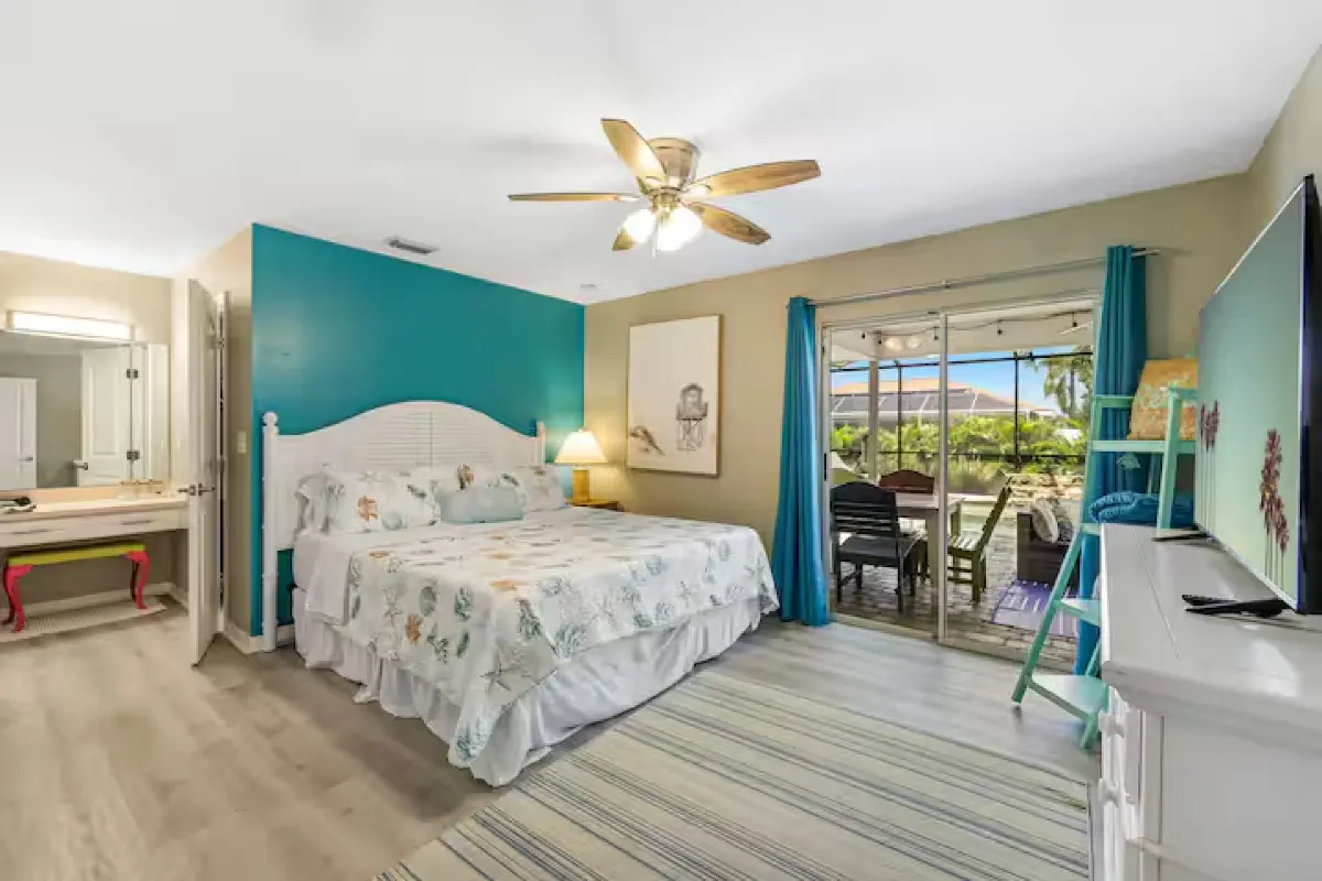 Bedroom with teal accent wall and ceiling fan